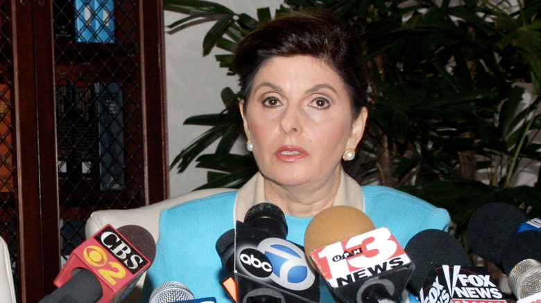 Attorney Gloria Allred speaking into several microphones