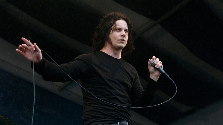Jack White in black outfit holding microphone