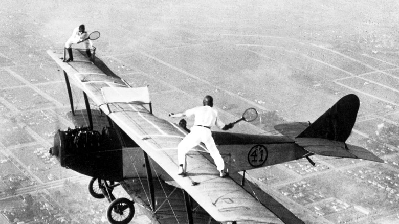 Gladys Roy playing tennis on top of an airplane