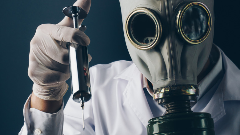 Masked scientist with a syringe