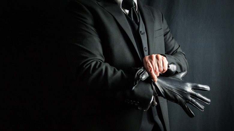 man in suit putting on glove