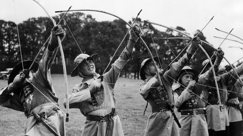 Archers in medieval costume drawing bows