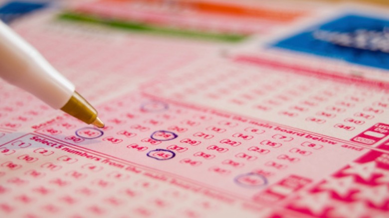 Pen circling numbers on lottery ticket