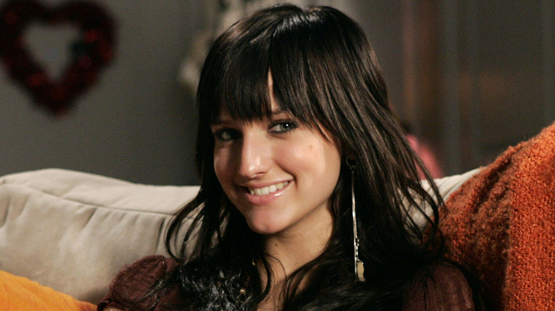 Ashlee Simpson sitting on couch and smiling at camera