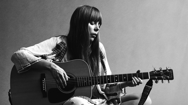 Joni Mitchell seated on the floor playing acoustic guitar, November 1968