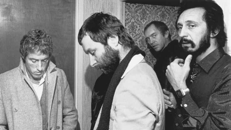 Roger Daltrey and John Entwistle of The Who looking upset in a hotel with two other men