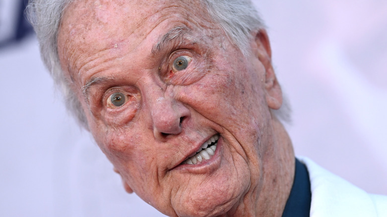 pat boone gurns on a red carpet in 2024