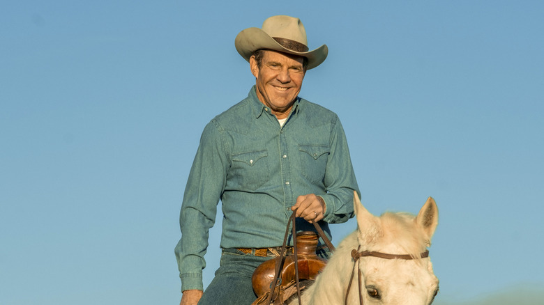 Dennis Quaid as Ronald Reagan riding horse and wearing cowboy hat