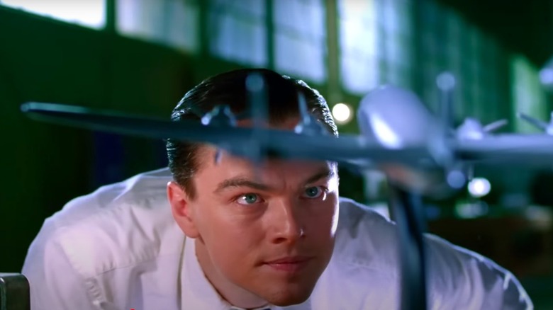 Leonardo DiCaprio as Howard Hughes looking at model plane in The Aviator