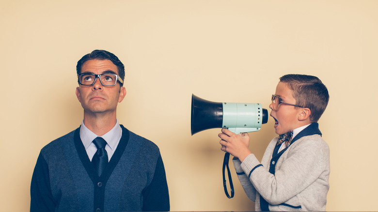 boy with megaphone pestering father
