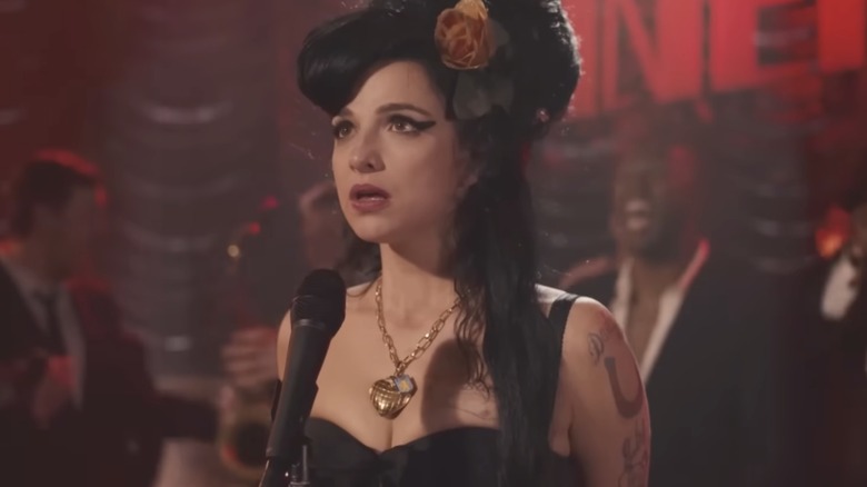 Marisa Abela as Amy Winehouse looking up by mic on stage