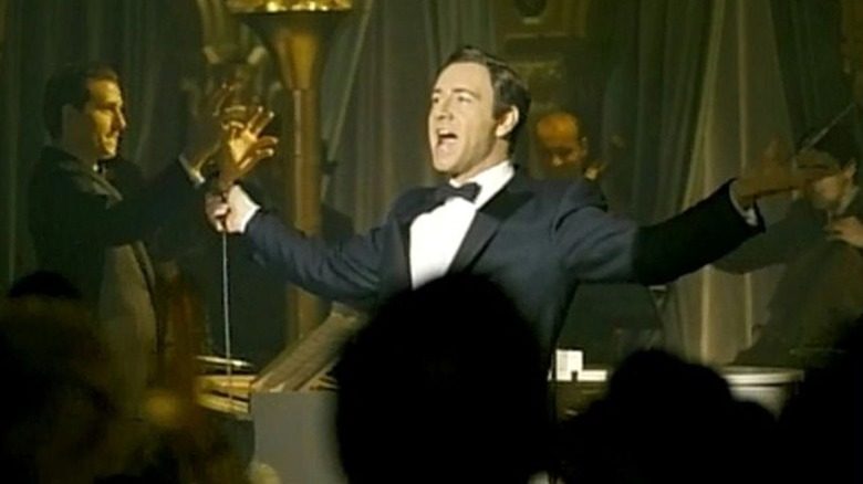 Kevin Spacey as Bobby Darin in suit with arms outstretched on stage