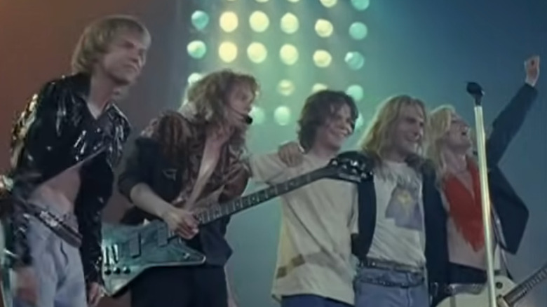 Def Leppard lined up on stage in a still from The Def Leppard Story