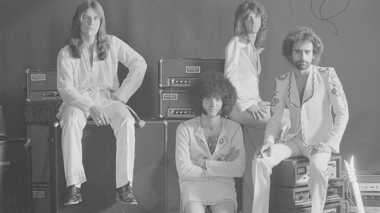 Grand Funk Railroad sat on and by speakers and music equipment