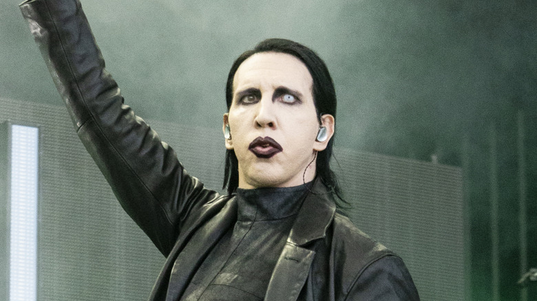 Marilyn Manson hoisting arm up on stage