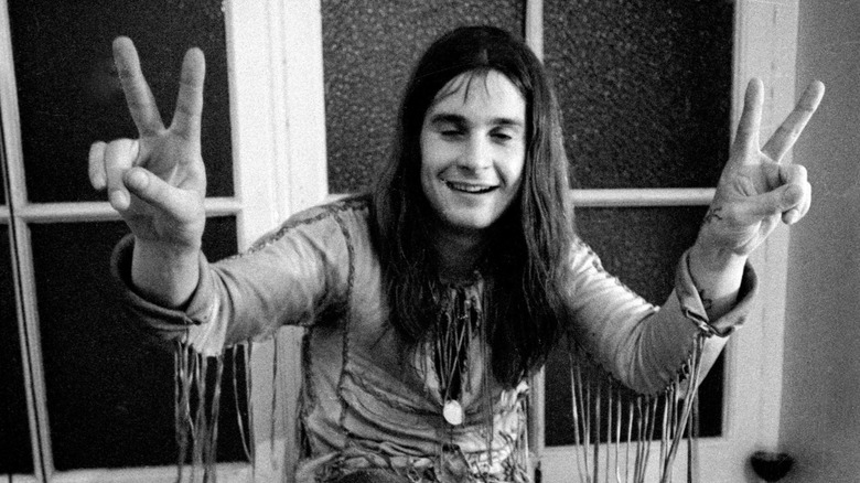 Ozzy Osbourne raising peace signs in both hands