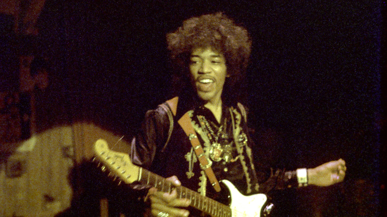 Jimi Hendrix onstage with guitar, smiling
