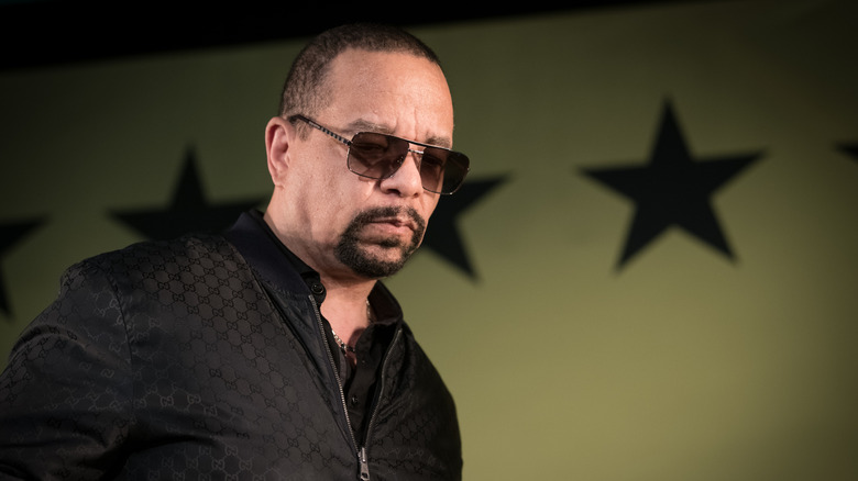 Ice-T performing in front of a wall of large, military-style stars