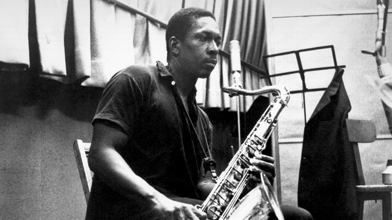 John Coltrane looking pensive holding an alto saxophone