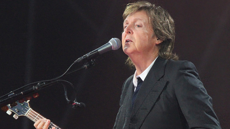 Paul McCartney playing bass on stage.