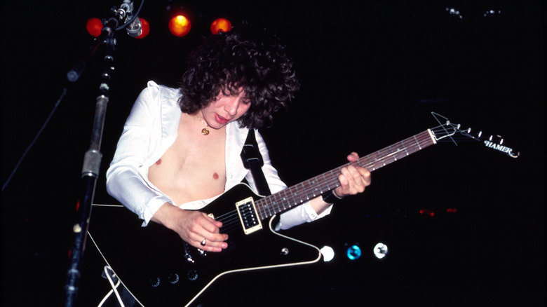Def Leppard's Pete Willis playing guitar on stage in 1981