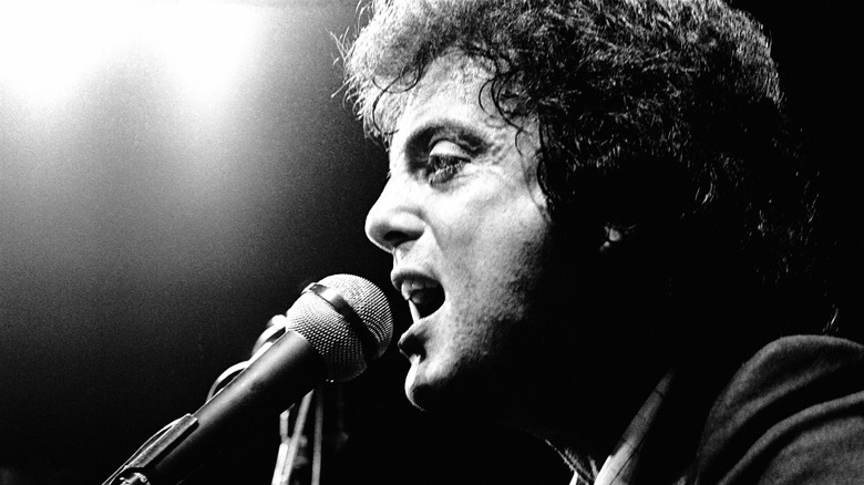 Billy Joel singing into mic on stage