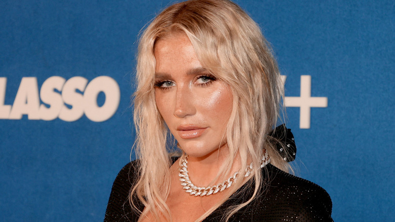 Kesha looking at the camera in black dress at event