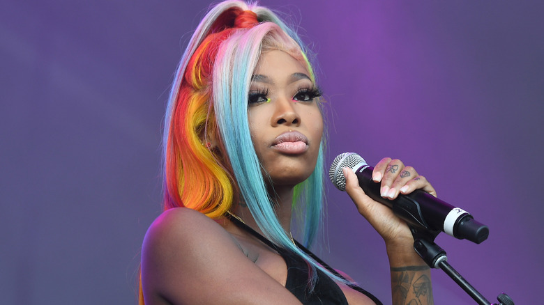 Summer Walker with rainbow hair holding mic on stage