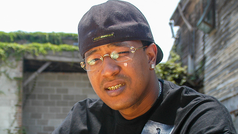 C-Murder squinting in backwards hat by brick wall