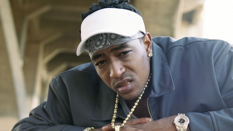 C-Murder in gold chain and visor sneering at camera