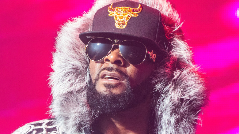 R. Kelly squinting in sunglasses and fur hood
