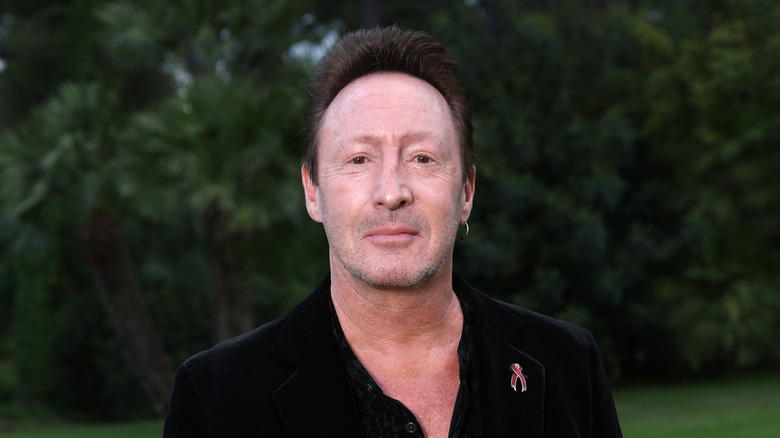 Julian Lennon posing in front of some trees