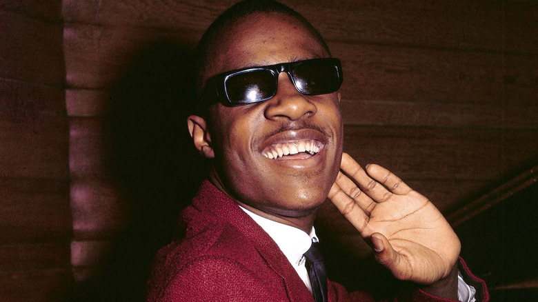 Stevie Wonder placing hand on ear