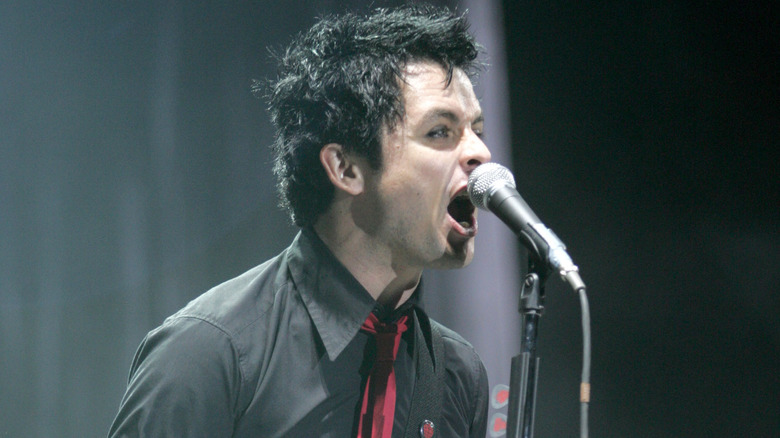 Billie Joe Armstrong black shirt red tie singing