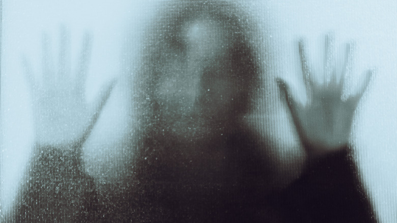 spooky woman behind a screen