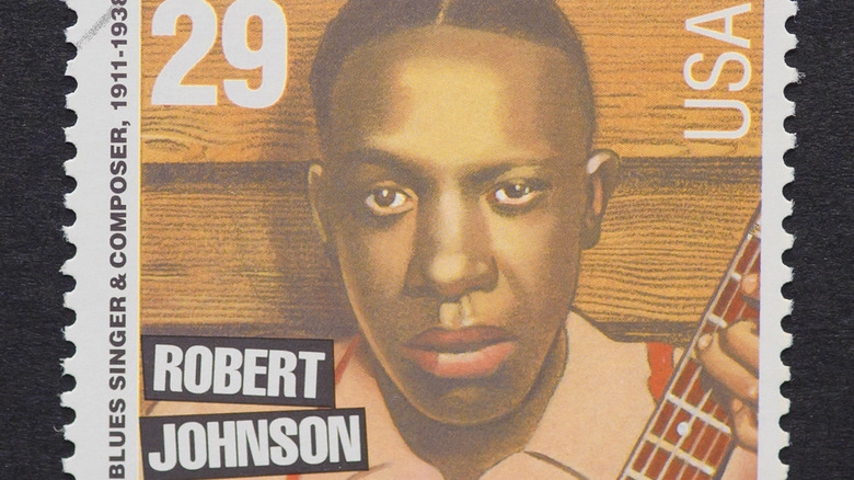 robert johnson playing guitar stamp