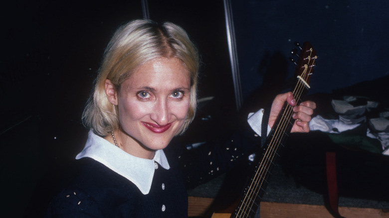 Jill Sobule smiling and playing mandolin