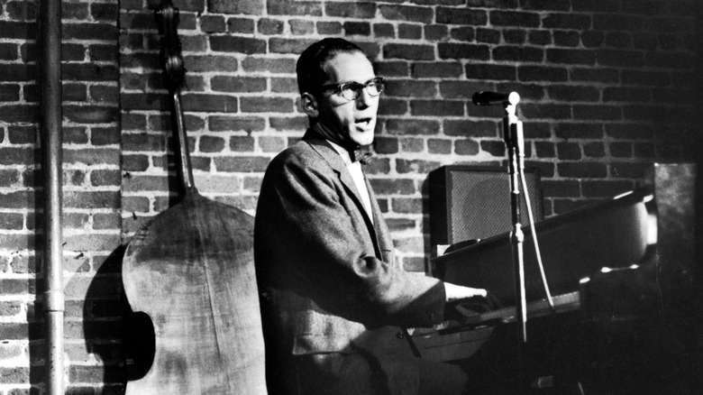 Tom lehrer performing at microphone