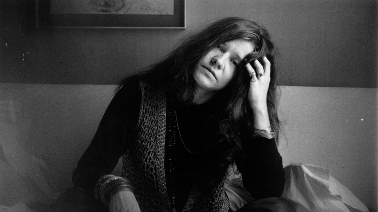 janis joplin sat on sofa leaning head on hand