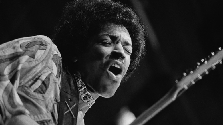 Jimi Hendrix mouth open playing guitar