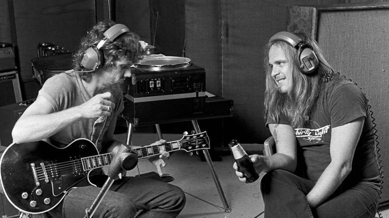 Ronnie Van Zant and Steve Gaines sat wearing headphone in studio