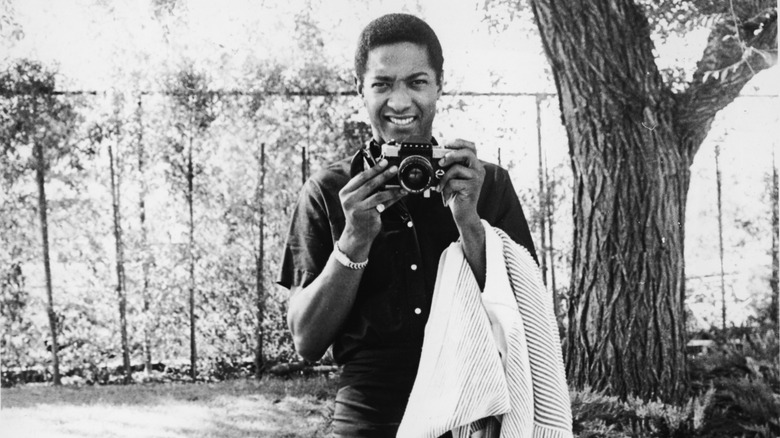 sam cooke smiling holding camera outside