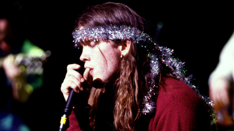 Shannon Hoon singing into microphone and wrapped in garland