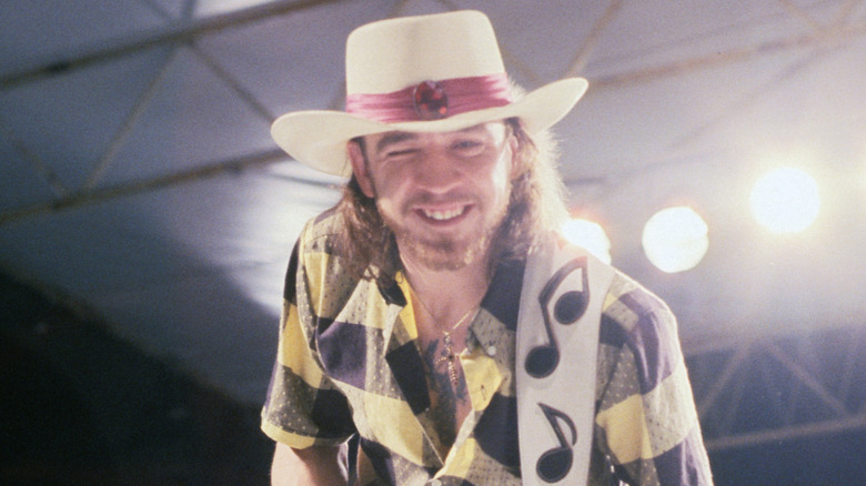 Stevie Ray Vaughan winking at camera while playing guitar
