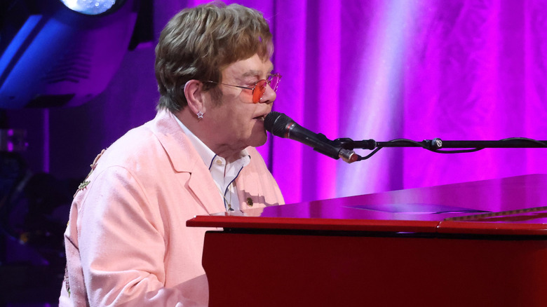 Elton John performing at piano on stage