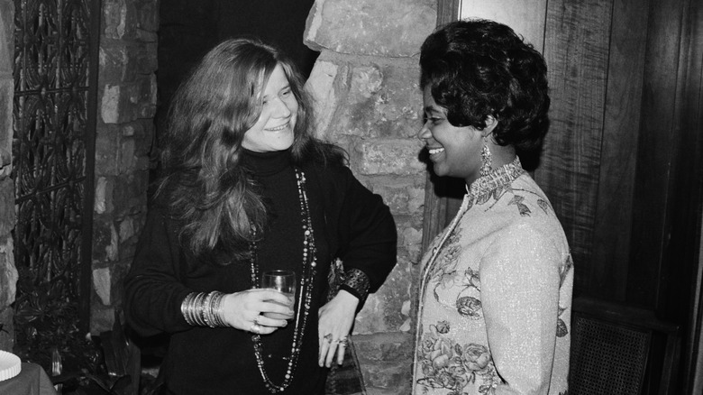 Janis Joplin laughing with Carla Thomas at a party