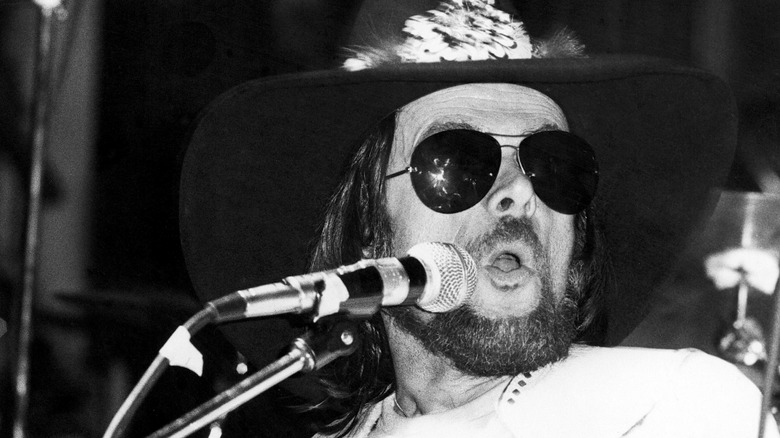Johnny Paycheck performing in cowboy hat and sunglasses