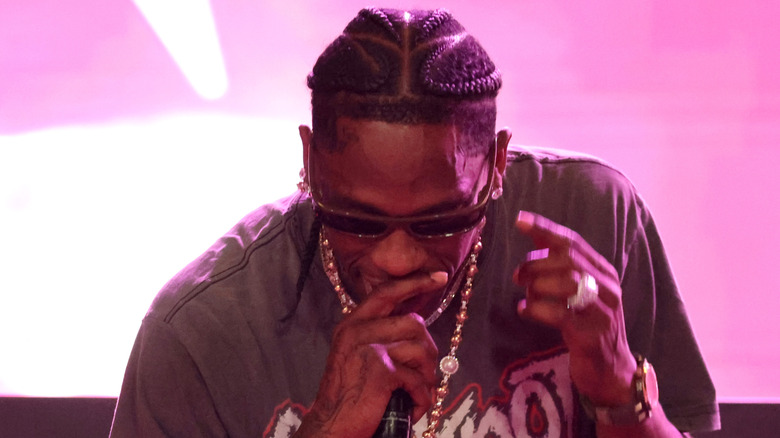Travis Scott looking down while singing onstage