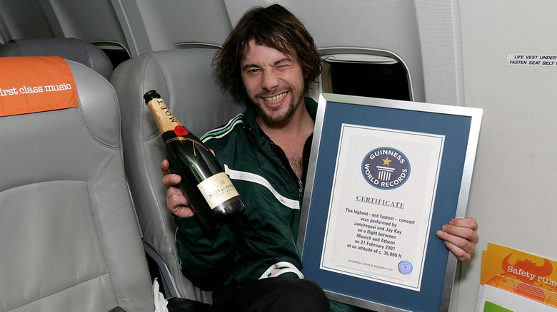 Jay Kay of Jamiroquai holding Guinness plaque on plane