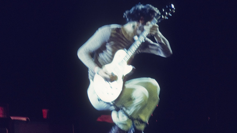 Pete Townshend jumping with guitar on stage in 1976